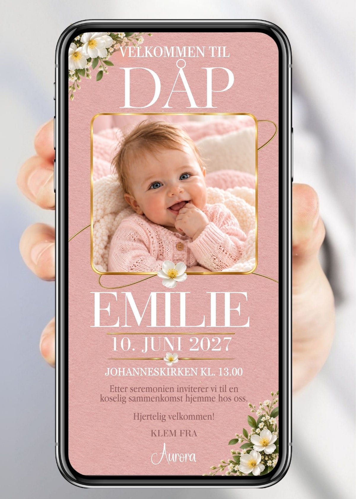 Invitasjon vist på mobil med overskriften «Velkommen til dåp», babybilde i gullramme, hvite blomster og grønne blader på dus rosa bakgrunn.