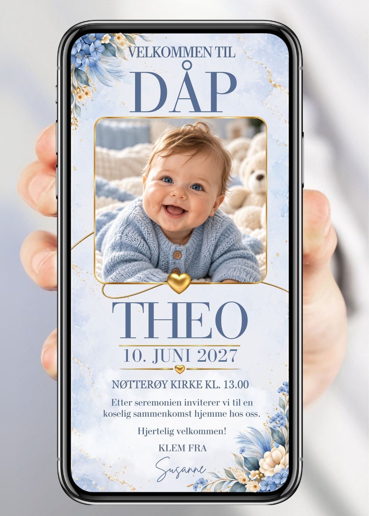 Dåpsinvitasjon vist på mobil, med babybilde i avrundet gullramme, blå og kremhvite blomster og gylne hjerter på lys, blåmarmorert bakgrunn.
