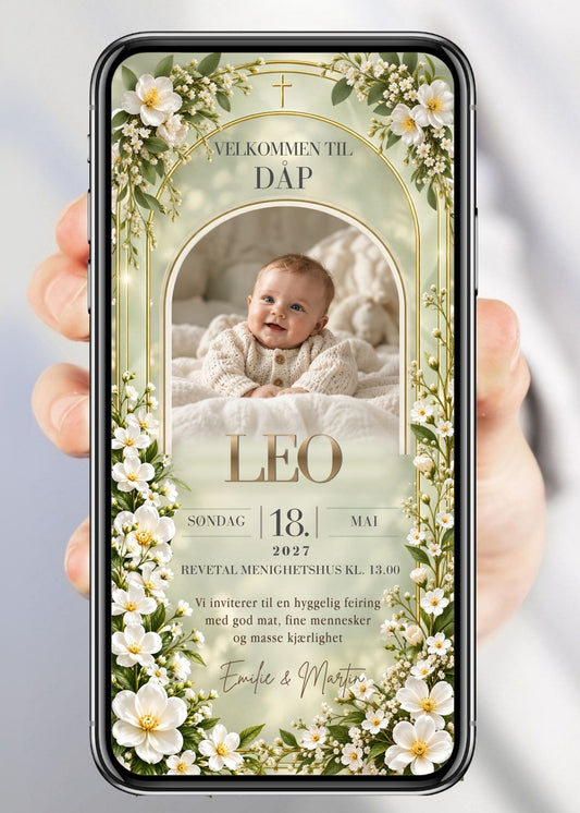 Invitasjon til dåp og navnefest med babyfoto i bueformet gullramme, gullkors øverst, hvite blomster og gypsophila rundt hele rammen, barnets navn i gull, dato, sted og håndskriftnavn på sageblå/mintgrønn bakgrunn